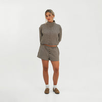Model wearing The Vivian Top in Houndstooth zipped to the funnel neck, front view, with matching shorts